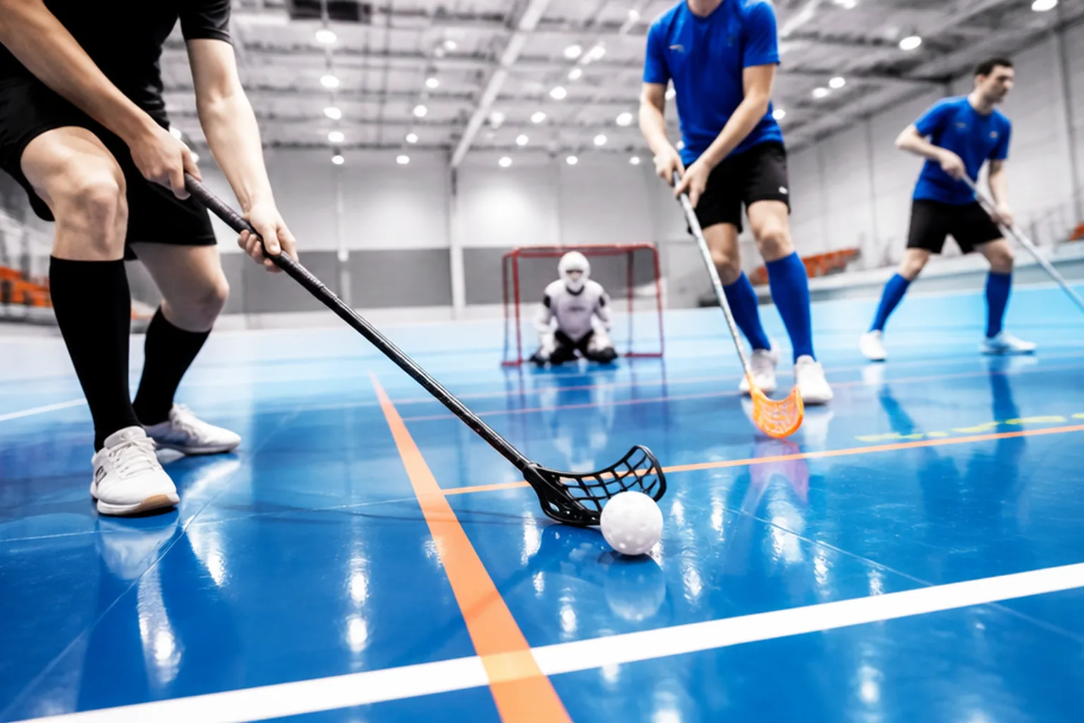 Innebandyplan i sporthall med tydliga sarglinjer och dramatisk takbelysning